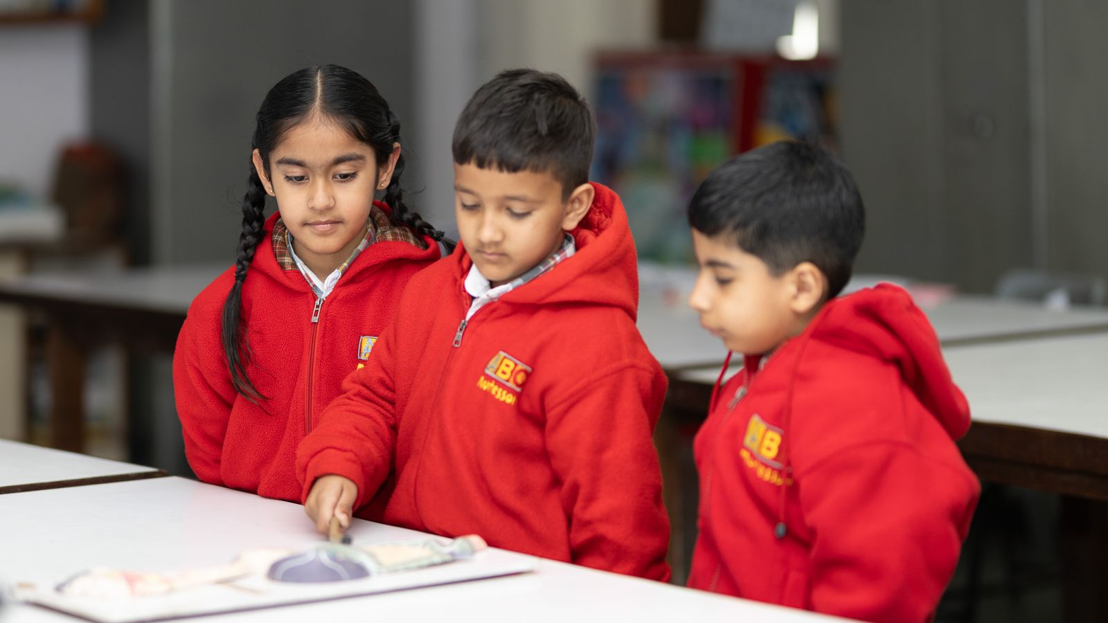 Elementary-aged students exploring a book together during a classroom activity