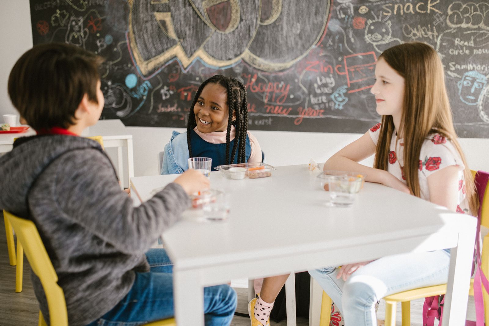 Elementary-aged students talking together around a classroom table