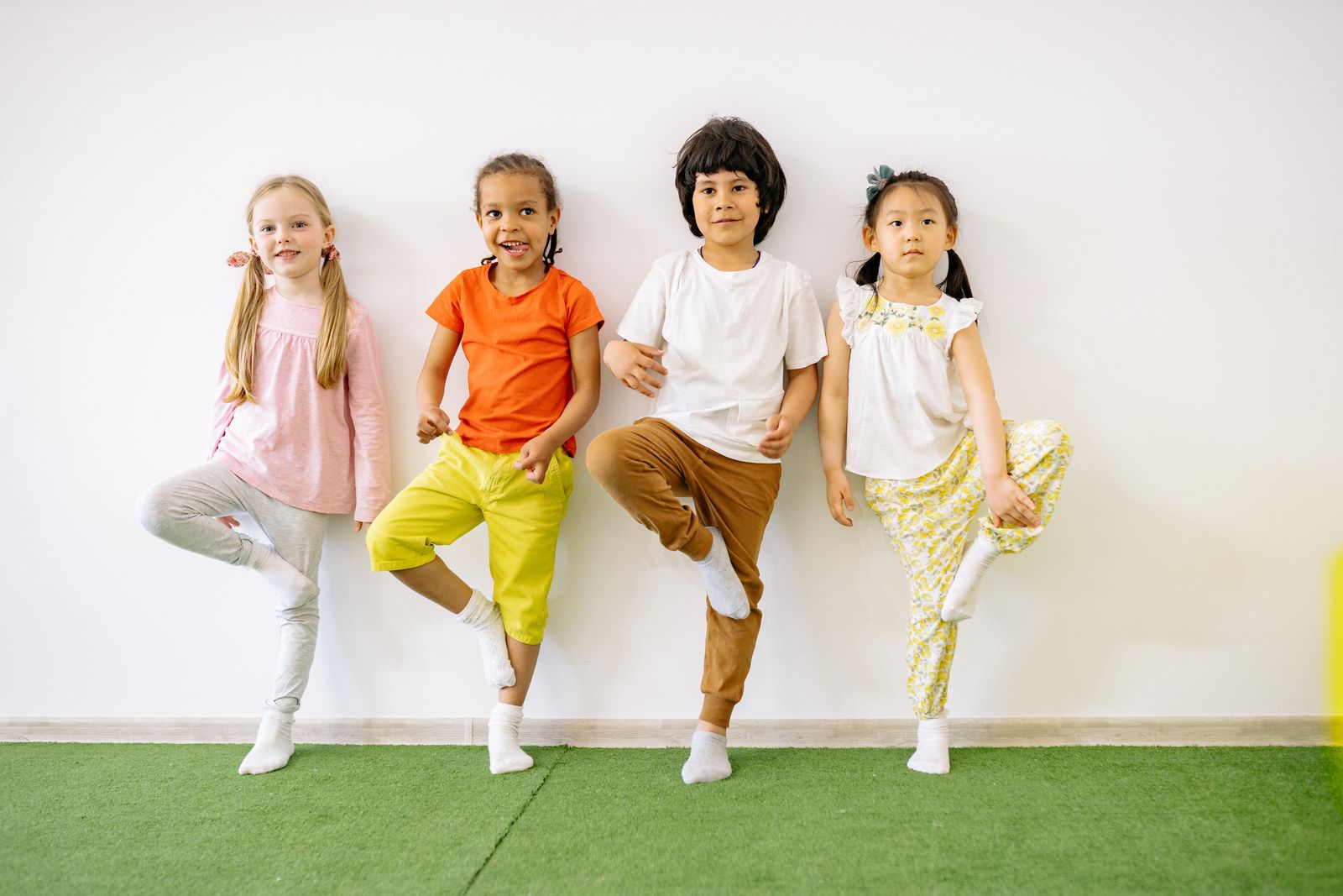Elementary-aged children balancing together during a classroom movement activity